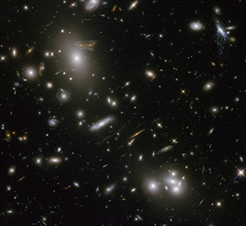 La masiva concentración de materia oscura y galaxias en el cúmulo Abell 68 curva el espacio tiempo a su alrededor desviando la luz de galaxias lejanas hacia nosotros. Crédito: Hubble ST/NASA.