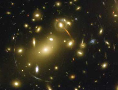 La masa del cúmulo de galaxias Abell 2218 sirve de lente para hacernos llegar la imagen distorcionada de un cuasar distante