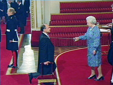 Investidura de Sir Timothy Berners-Lee, el padre de la web en el Palacio de Buckingham Palace, arrodillado mientras es ordenado Caballero Comandante por la Reina Isabel II de Inglaterra.