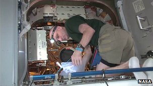 El especialista Don Petit descarga la cápsula Dragon en la EEI. Crédito: NASA.