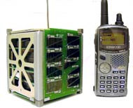 El picosatélite colombiano Libertad 1, comparado con un transmisor manual. Crédito: USA.